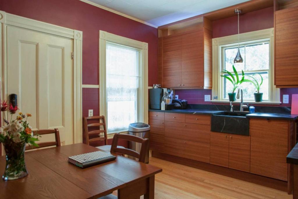 剑桥Luxury Harvard/MIT Victorian的厨房配有木制橱柜和木桌。