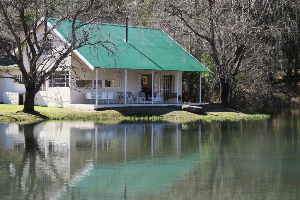 海姆维尔Mkomazana Mountain Cottages的水边有绿色屋顶的房子