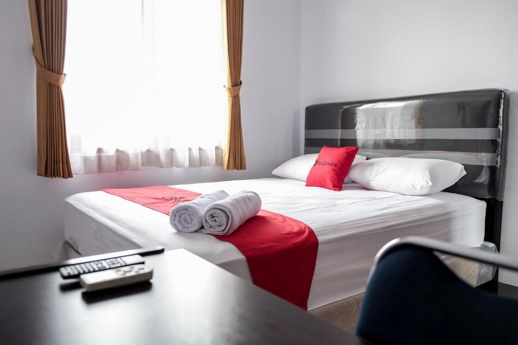当格浪RedDoorz near Supermall Karawaci 2的酒店客房带两张带红白色枕头的床
