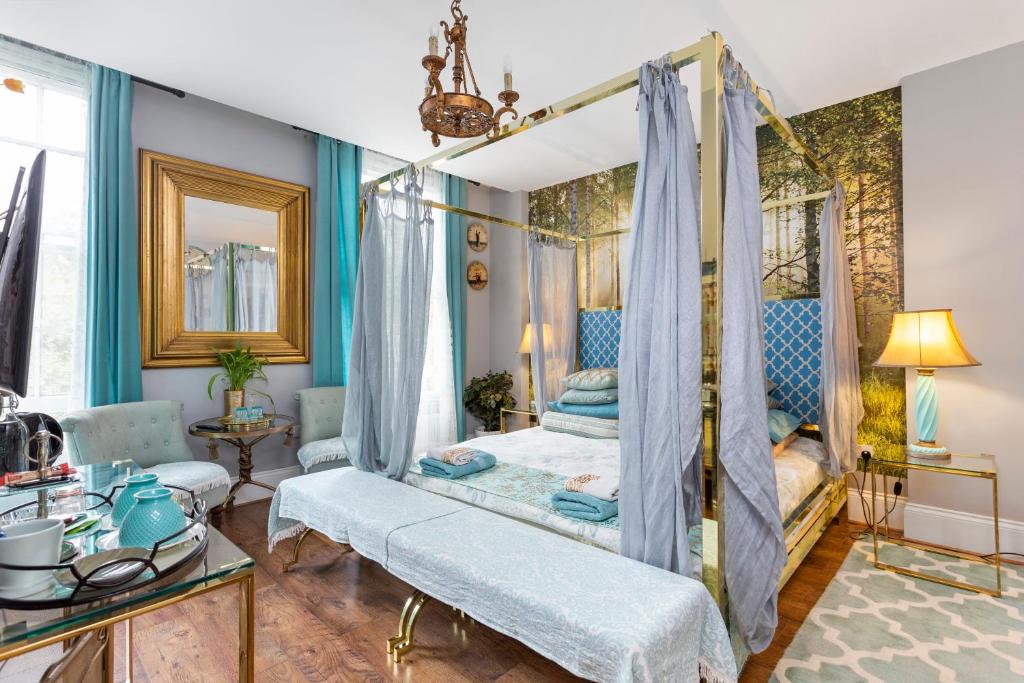 诺丁汉妈妈旅馆的一间卧室配有一张天蓬床和蓝色的墙壁