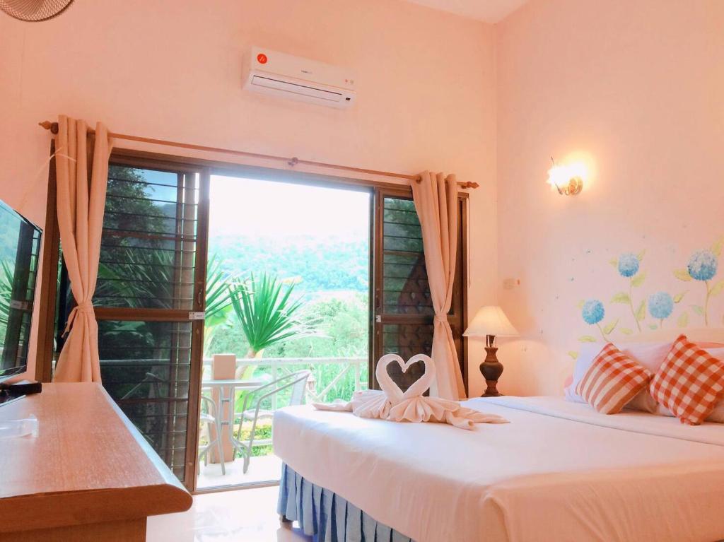 黎府Phurua Bussaba Resort & Spa的一间卧室设有两张床和大窗户