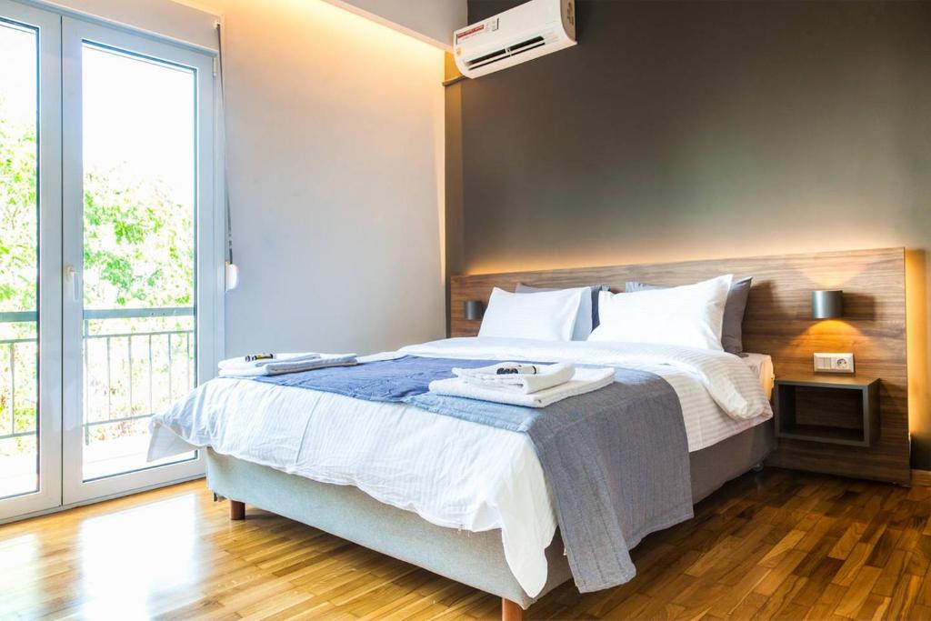 雅典TONI'S Comfy 3BD home with patio, close to Metro的一间卧室设有一张大床和一个大窗户