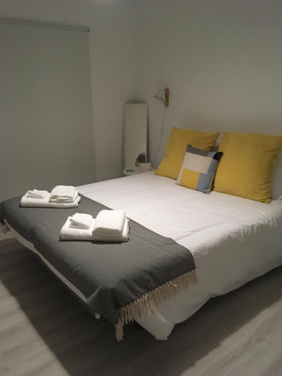 福斯·杜·阿勒奥Salty House - Casa Salgada的一间卧室配有一张大床和毛巾