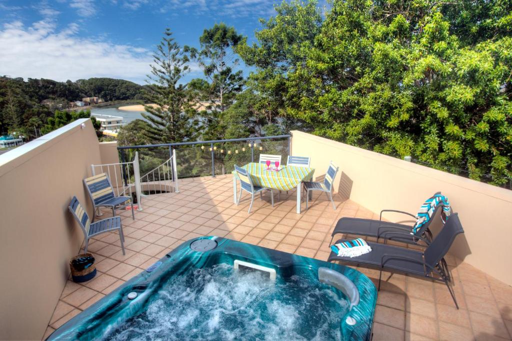楠巴卡黑兹oceanview 6 with rooftop terrace & spa的庭院内的热水浴池,配有桌椅