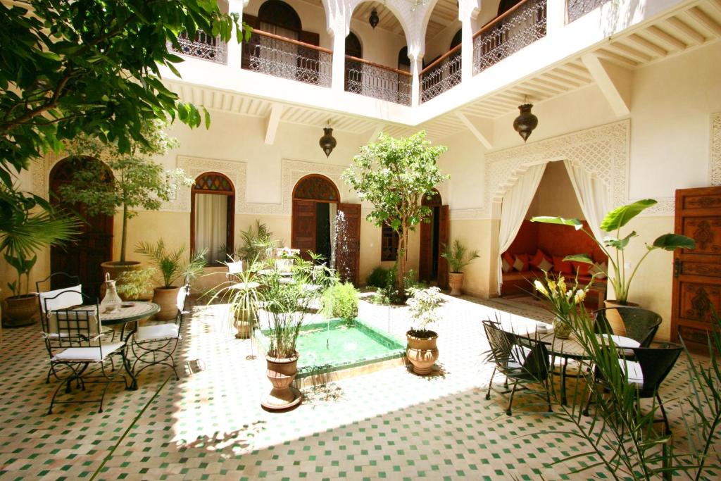 马拉喀什里亚德马思巴摩洛哥传统庭院住宅的庭院里有一个游泳池和很多植物