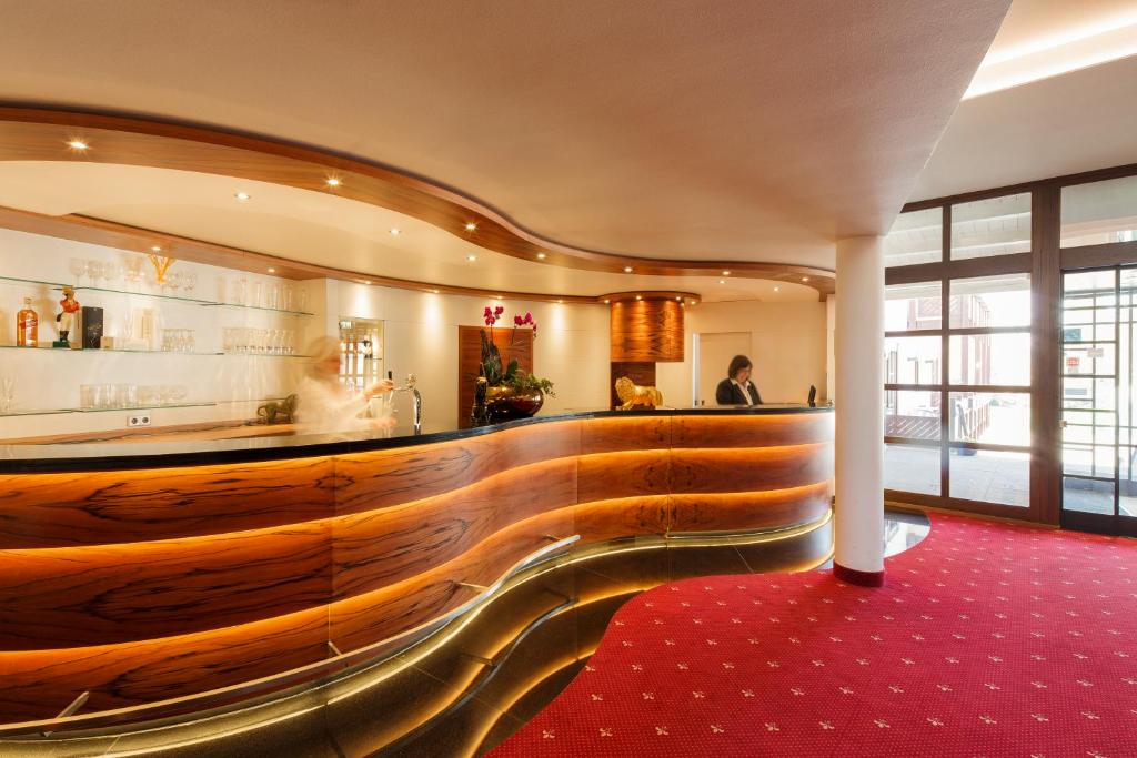 弗莱堡茵维特洛文弗赖堡酒店的大堂设有铺有红地毯的木制酒吧