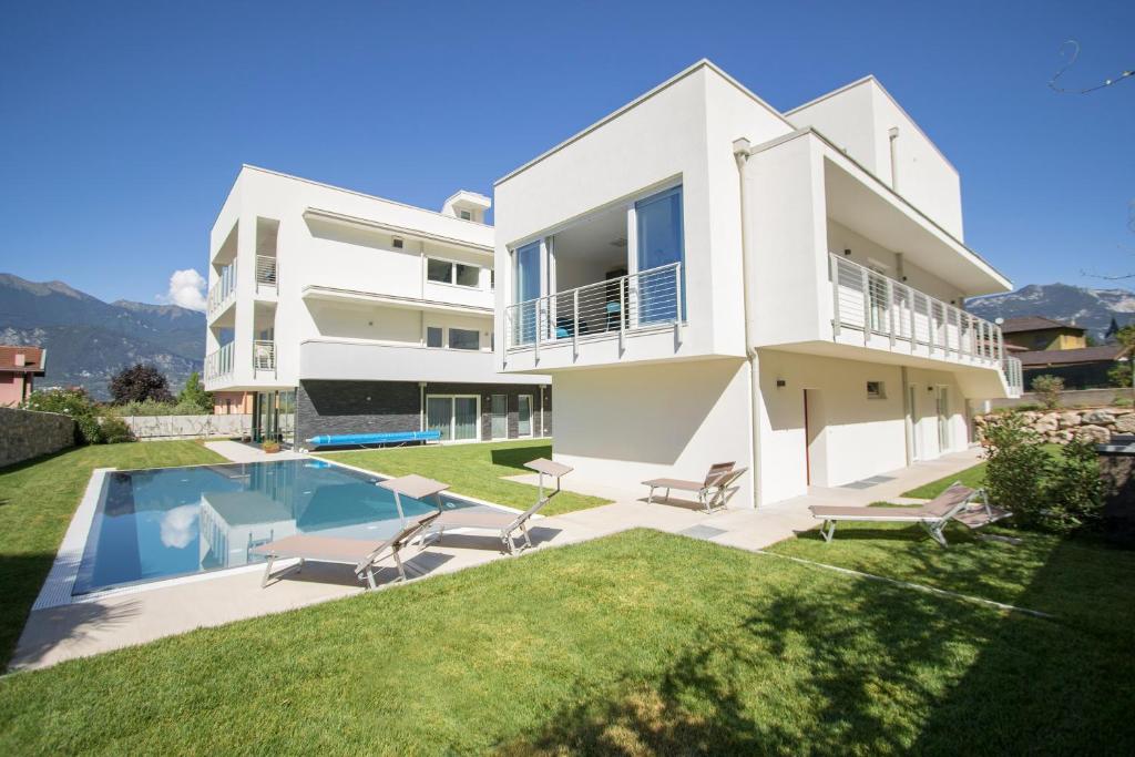 阿科Residenza Cinisca的一座带游泳池和庭院的白色房子
