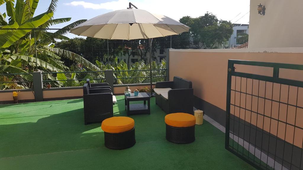 丰沙尔FX Pena的庭院配有遮阳伞和桌椅。