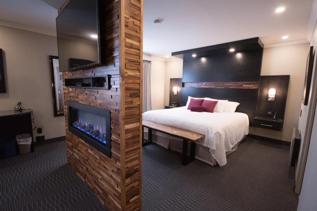Amos德斯艾斯科尔斯酒店的一间酒店客房,配有一张床、一个壁炉和一台电视