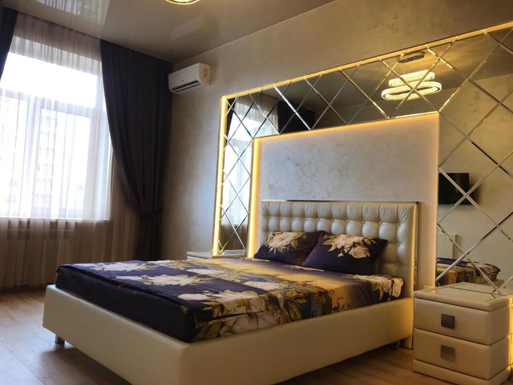 哈尔科夫Luxury Apartment in Downtown, Near River Esplanade的一间卧室配有一张金色床架的大床