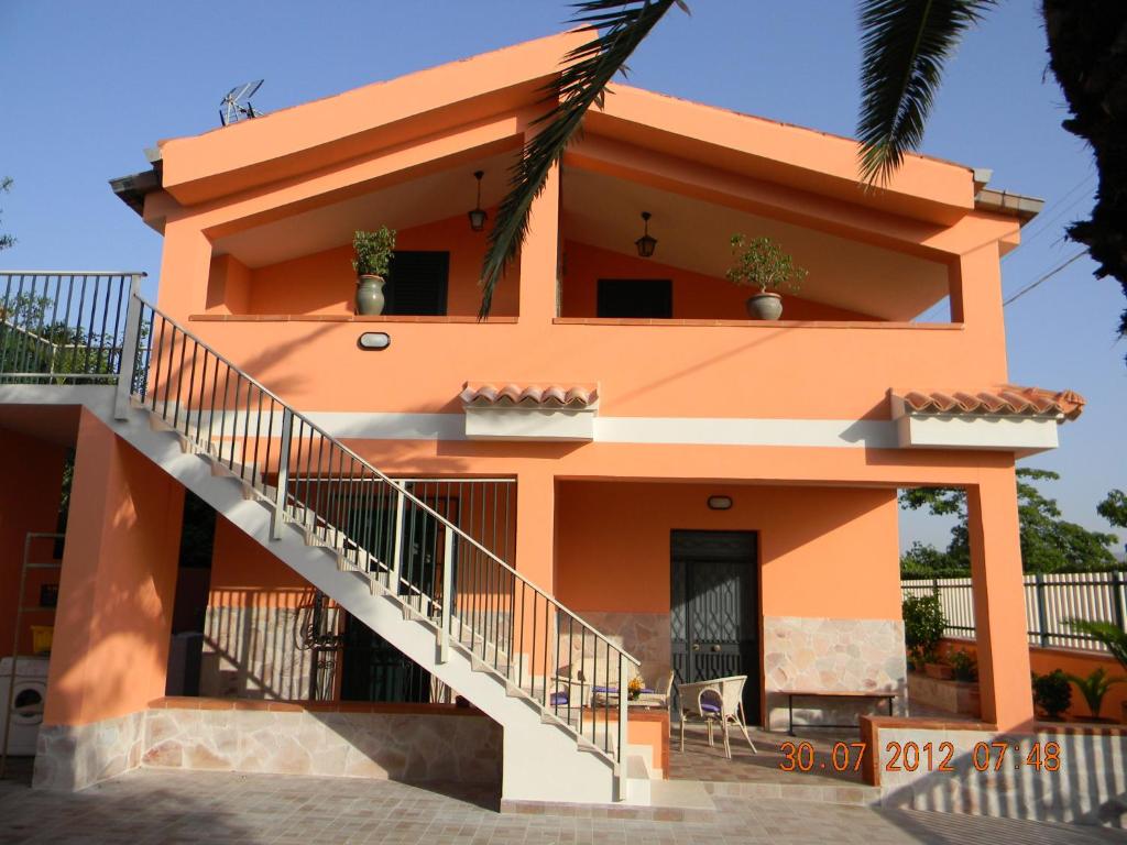 诺托玛丽娜Casa Concetta的一座橙色房子,前面有楼梯