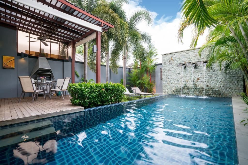拉威海滩Two bedrooms pool villa at Saiyuan estate的房屋旁的带桌椅的游泳池