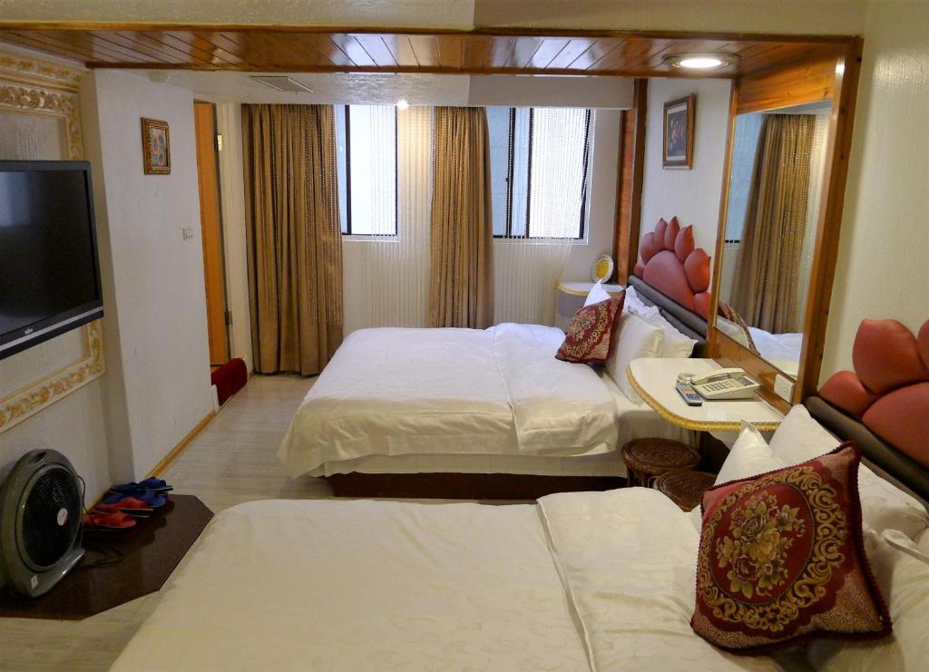基隆阿乐哈大饭店的酒店客房设有两张床和一台平面电视。
