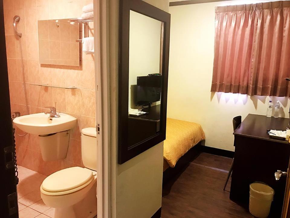 台东假期商务旅馆的一间带卫生间和水槽的浴室