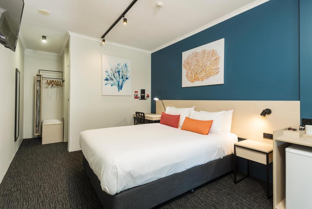 凯恩斯山脊酒馆旅馆的一间卧室设有一张床和蓝色的墙壁