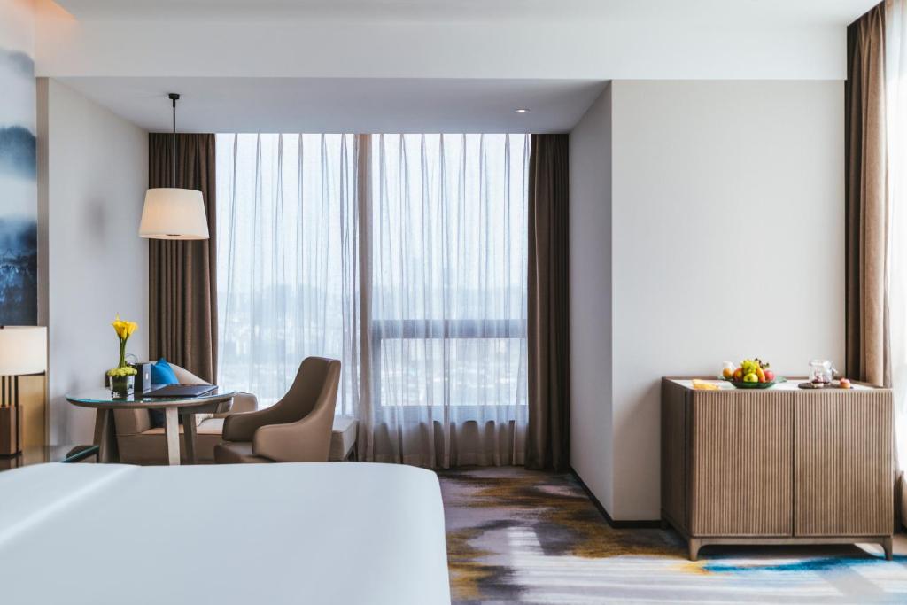 福州福州泰禾铂尔曼酒店的配有一张床和一张书桌的酒店客房