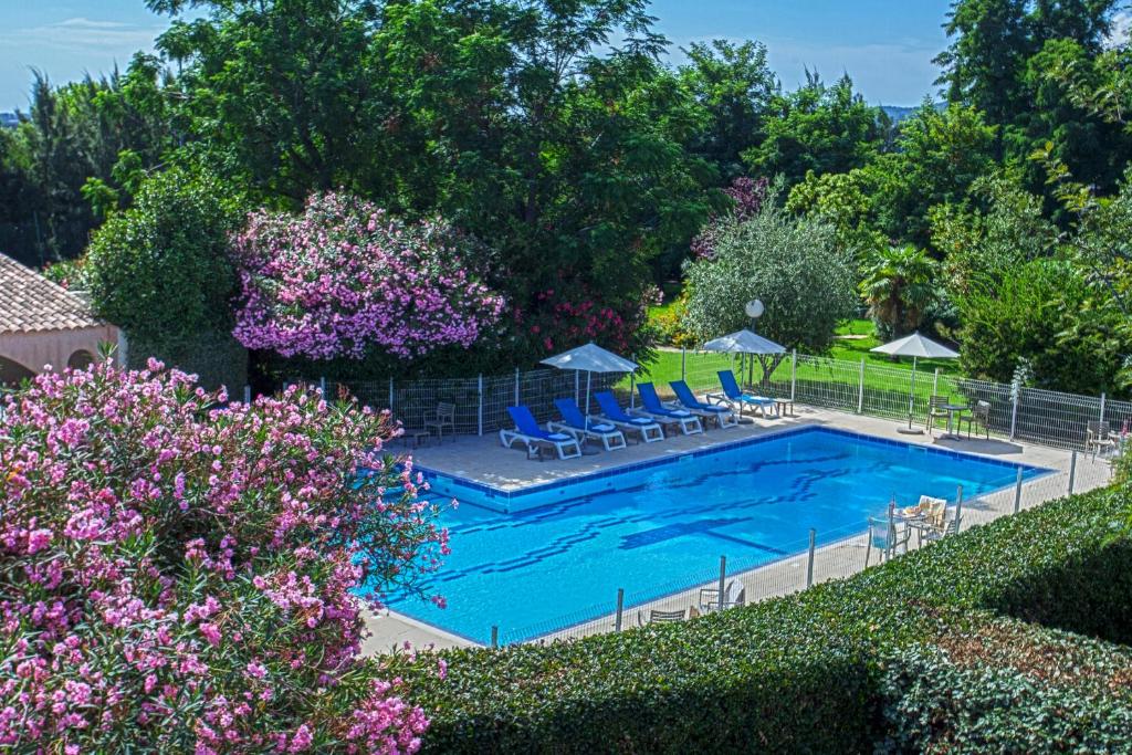 卢恰纳瓦尔特家庭酒店的庭院内一个带椅子和遮阳伞的游泳池