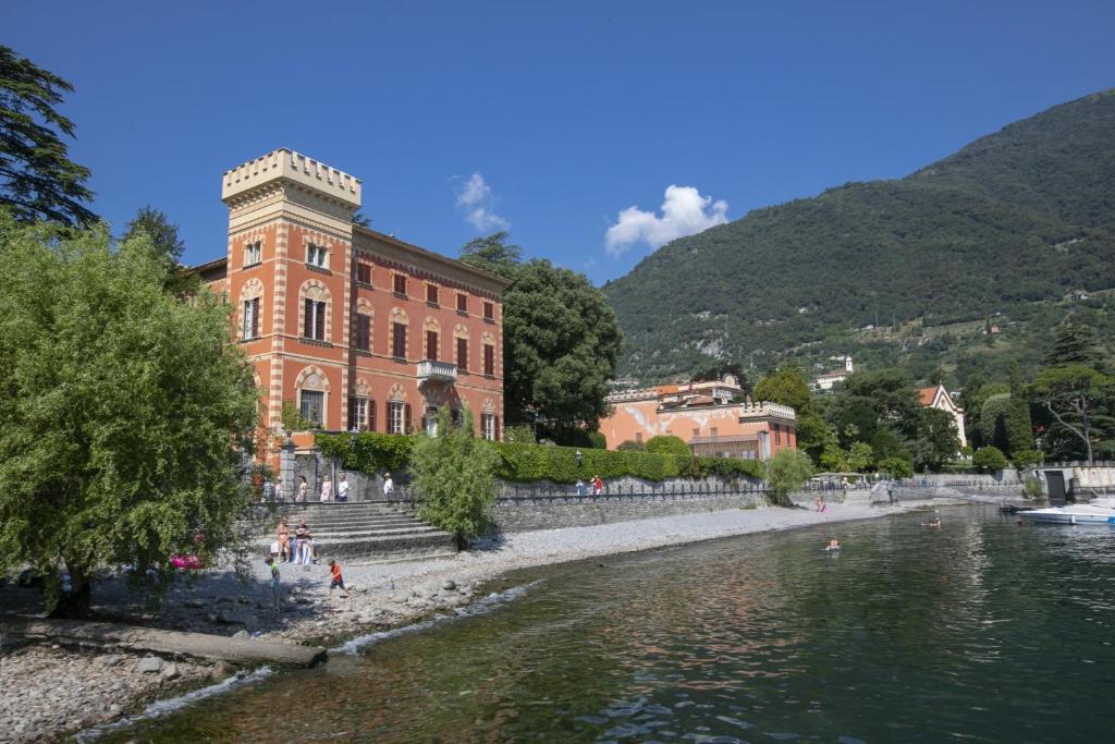 伦诺Lenno Giardinetto的水体旁边的一个大砖砌建筑