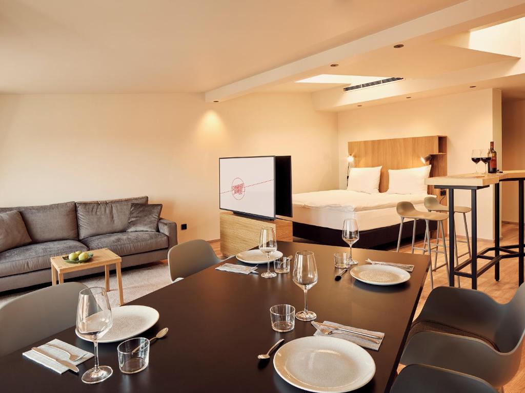 慕尼黑考斯莫帕里坦酒店的客厅配有桌椅和1张床