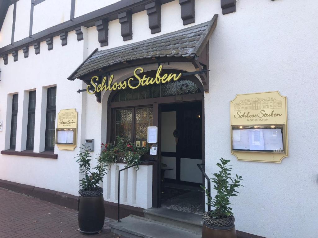 NordkirchenHotel SchlossStuben的建筑前有标志的商店