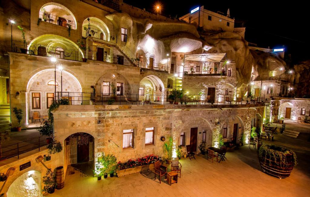 格雷梅赫拉凯弗套房酒店的一座古老的石头建筑,晚上有庭院