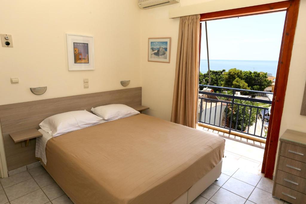 阿吉亚玛丽娜Hotel Karyatides的一间卧室设有一张床和一个大窗户