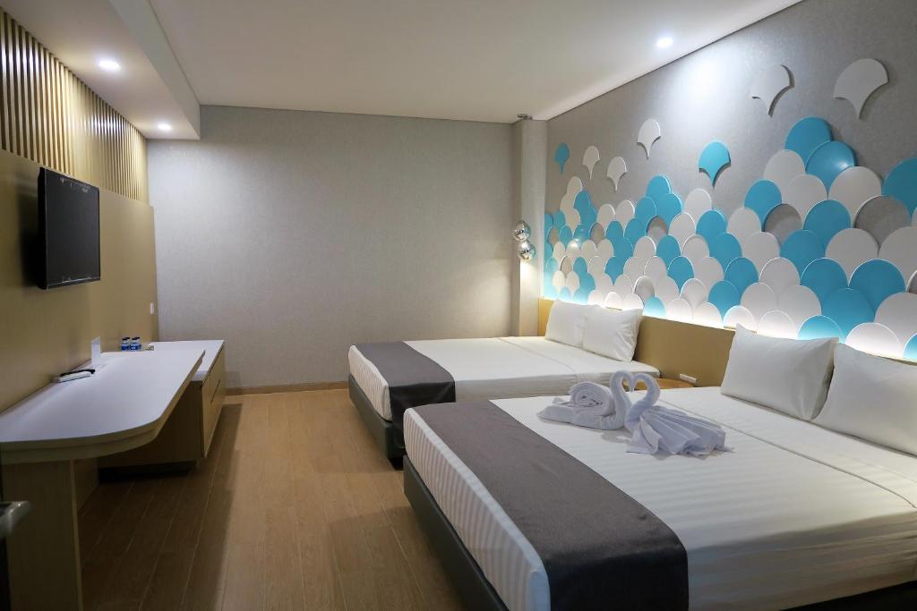 三宝垄Nomaden Urban Stay的酒店客房设有两张床和盥洗盆