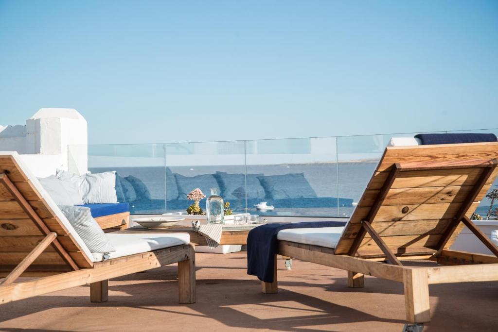 阿列塔Modern home with Ocean View的两把木椅位于甲板上,享有海景