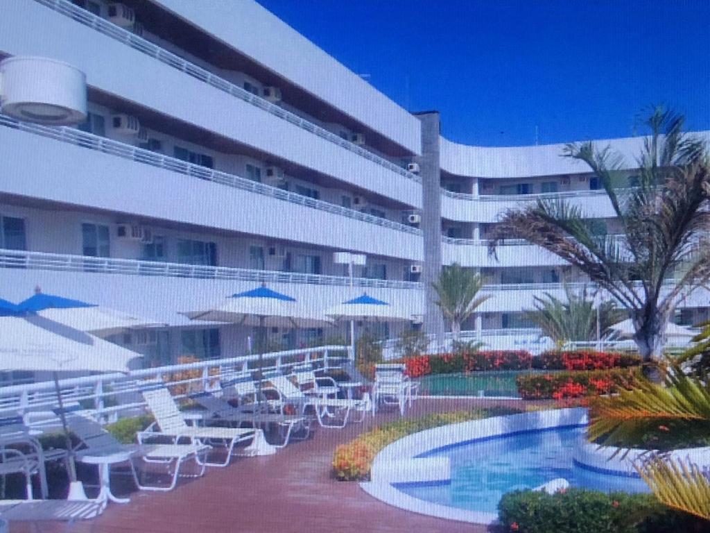 帕纳米林Blue Marlin Resort&Spa的一个带游泳池和椅子的度假胜地和一座建筑