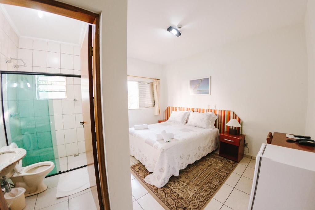 因达亚图巴帕萨勒杜酒店的一间卧室配有一张床,浴室设有淋浴。
