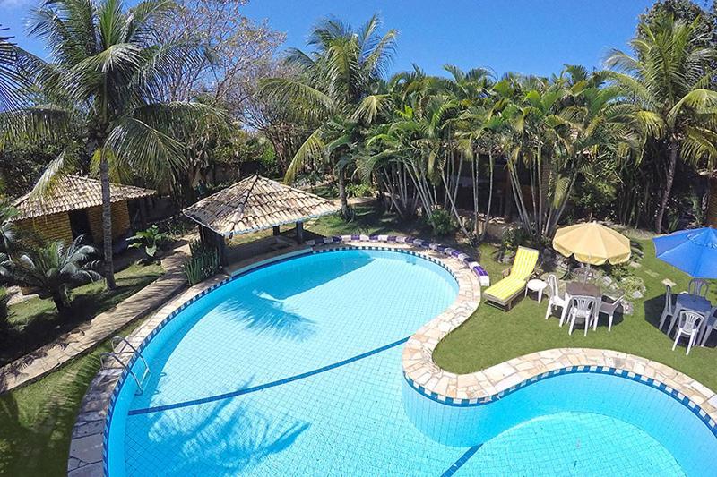 皮帕卡诺阿斯欧罗索尔客栈的一座带桌椅和棕榈树的大型游泳池