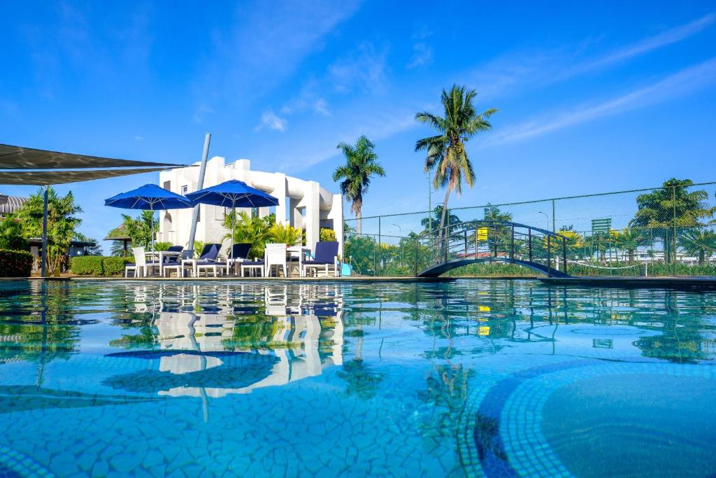 南迪斐济盖特威酒店的大楼前的带椅子和遮阳伞的游泳池