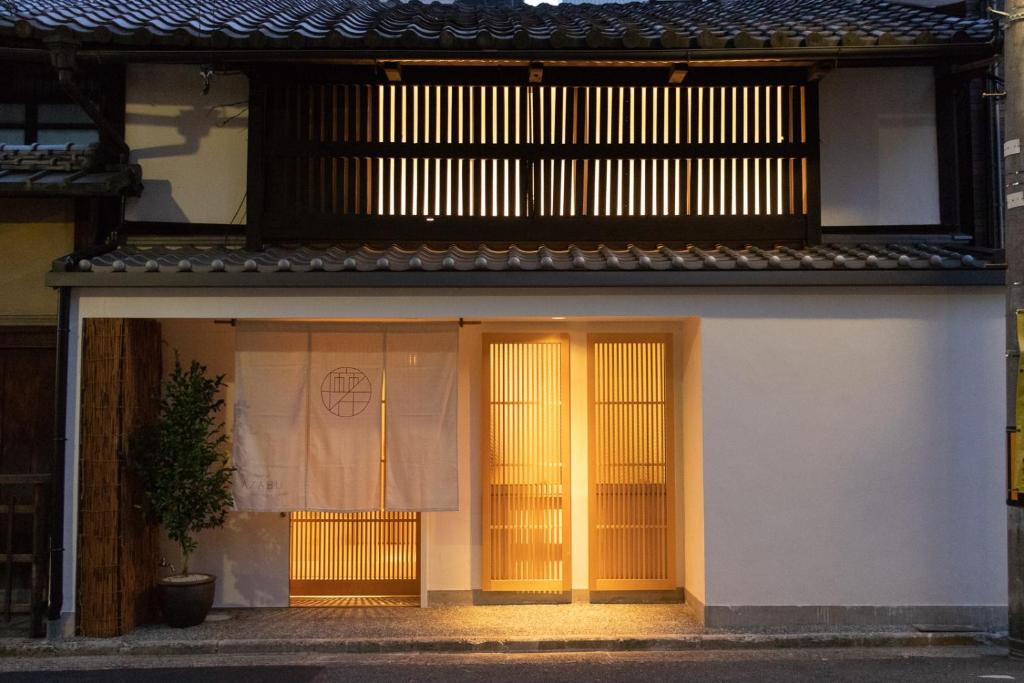 京都AZABU旅馆的白色的建筑,设有黄色的门和窗户