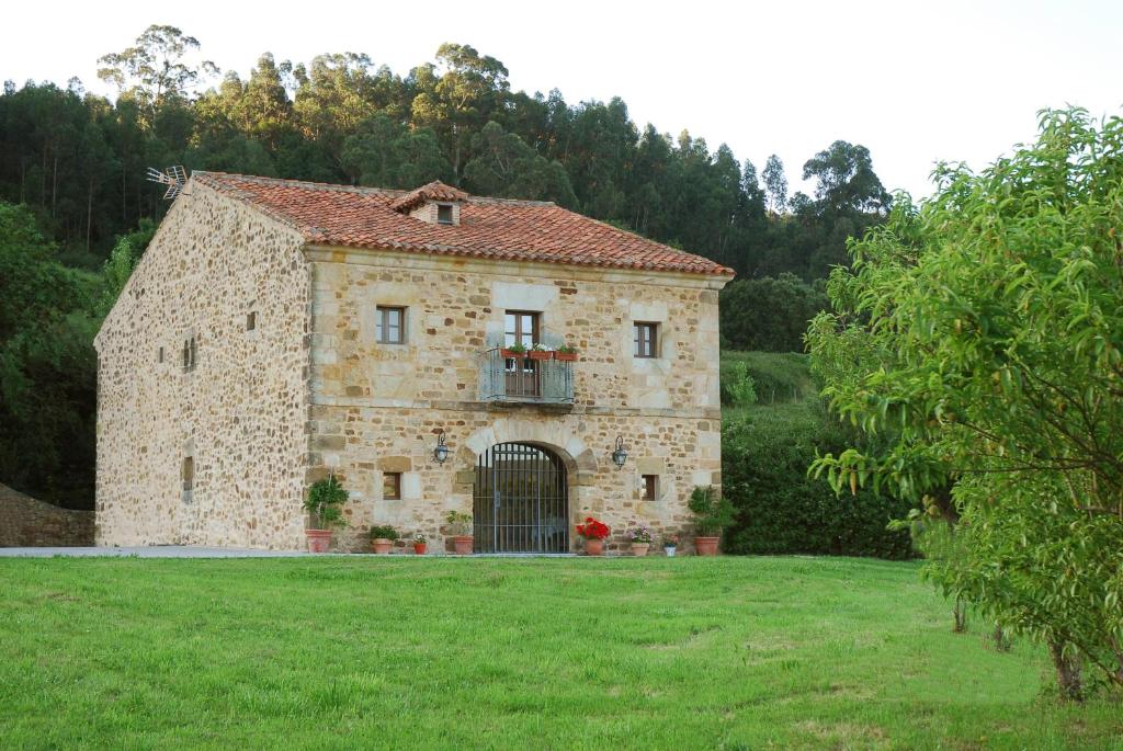 圭梅斯Posada Camino del Norte的一座古老的石头建筑,在田野上设有大门