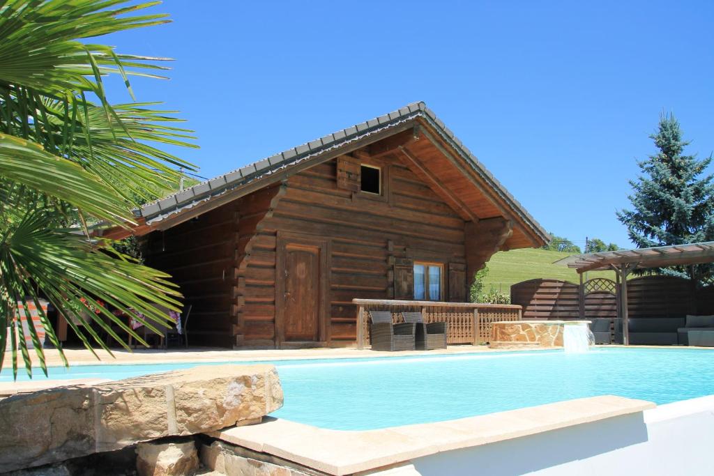 伊帕尼Chalet le Pré de la Dame的小木屋,房子前设有游泳池