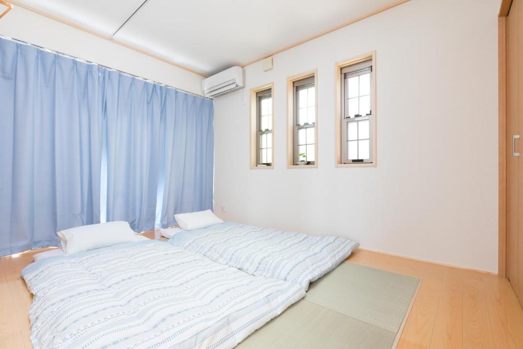 泉佐野JIYUKA INN的蓝色窗帘的房间的一张床位