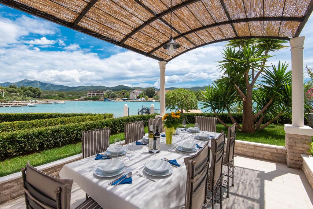 洛维什特Villa Loviste Paradise的露台上的桌子享有水景