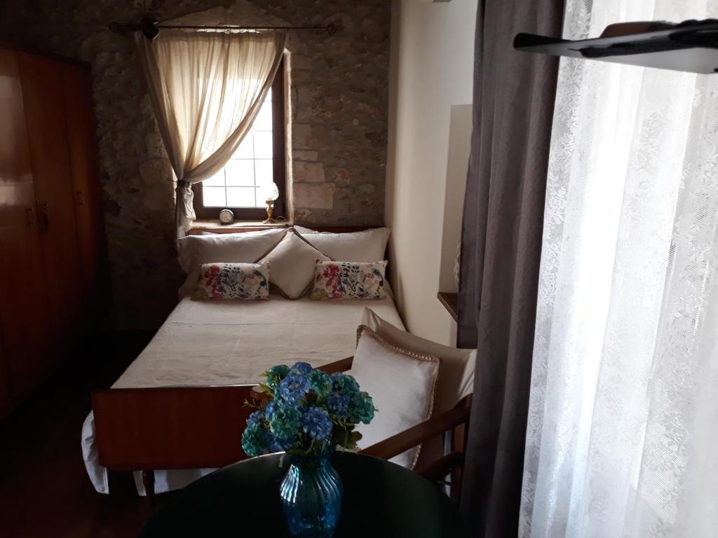 赫索尼索斯Koutouloufari Cosy Cretan Cottage的一间卧室,配有一张带花瓶的桌子