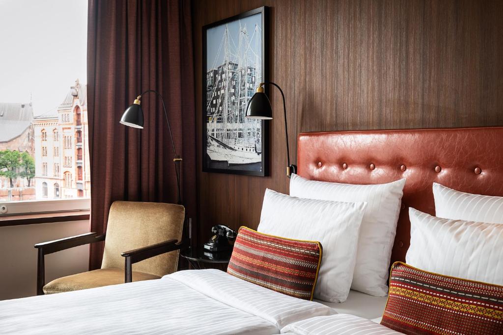 汉堡阿美龙汉堡斯佩切尔斯塔特酒店的酒店的客房 - 带一张床、椅子和窗户