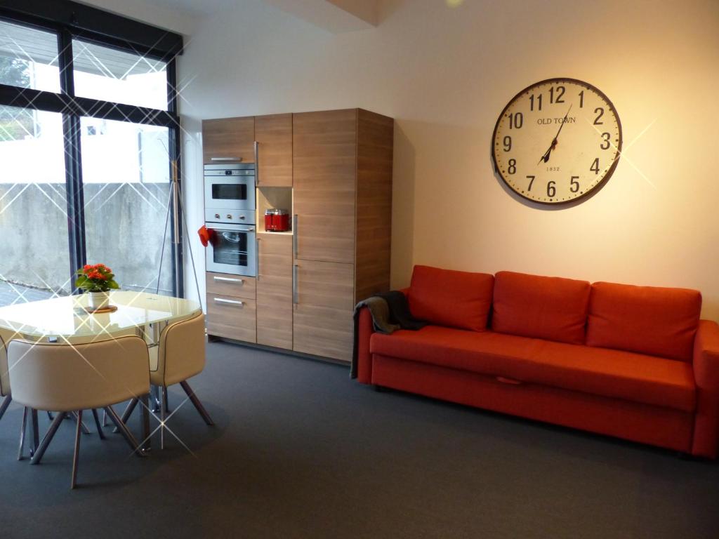 奥尔西讷volcaloft的客厅配有沙发和墙上的时钟