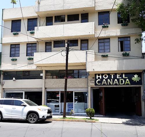 托卢卡Hotel Canadá的停在酒店前的白色汽车