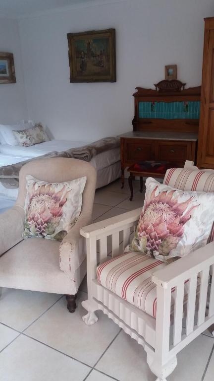 阿古拉斯吉夫特民宿的客厅配有两把椅子和钢琴
