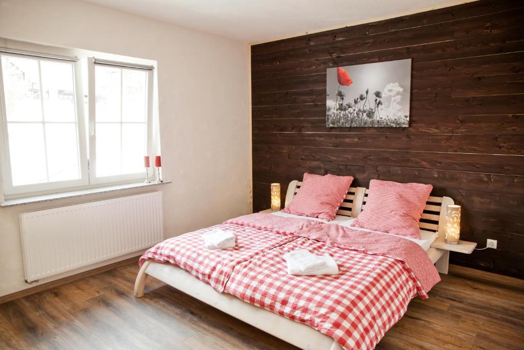 霍姆贝格Landhaus im Rinnetal的一间卧室配有一张带红白毯子的床
