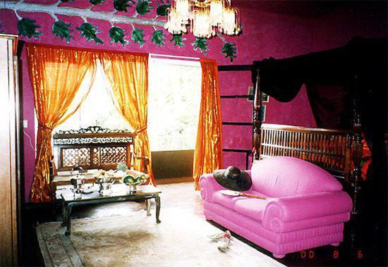 康提赫尔佳思富力安提酒店公寓的粉红色的客房配有粉红色的沙发和桌子