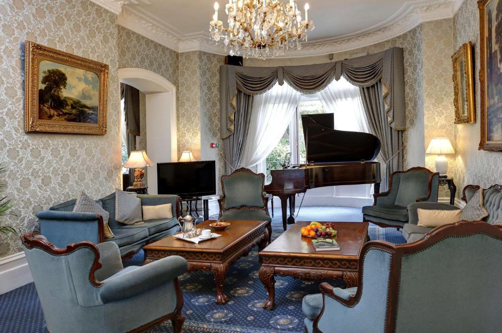 伦敦贝斯特韦斯特瑞士小屋酒店的一间带钢琴的客厅和一间带椅子的客厅