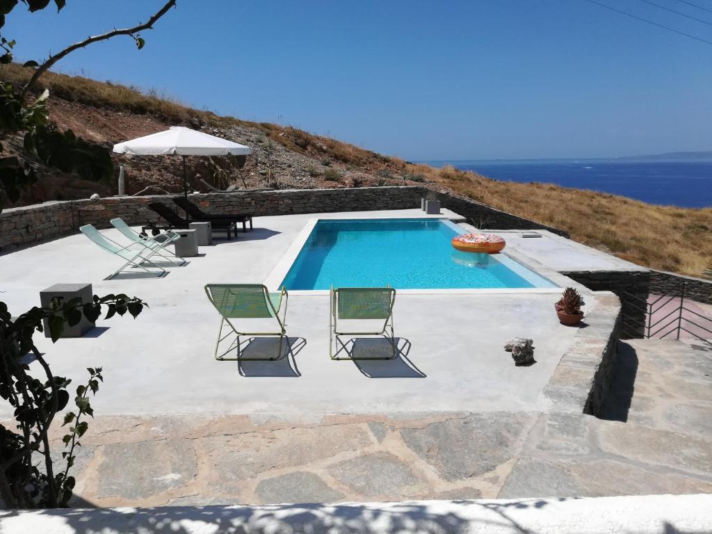 科里夏Villa with Swimming Pool的一个带两把草坪椅的游泳池和海洋