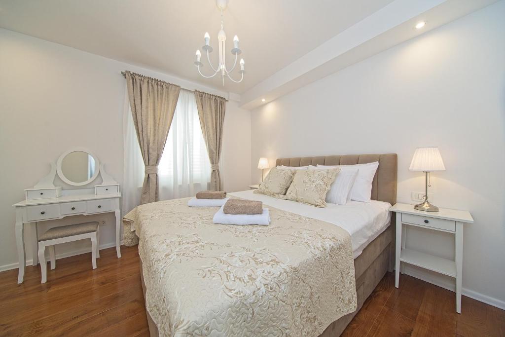 斯顿Apartment Marangun的白色卧室配有床和镜子