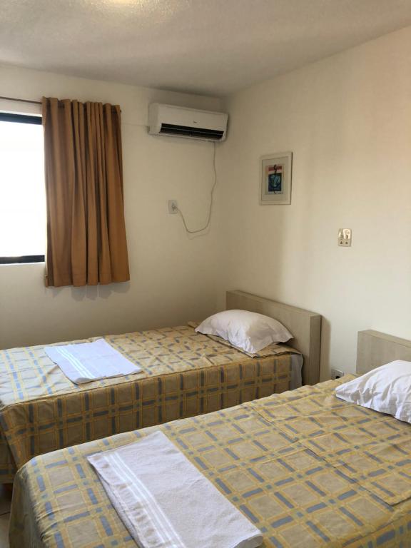 圣路易斯Melo Hospedagem - Flat Bellagio的酒店客房设有两张床和窗户。