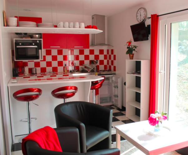 库洛米耶Birchbank Cottage的厨房设有红色和白色的厨房,配有桌椅