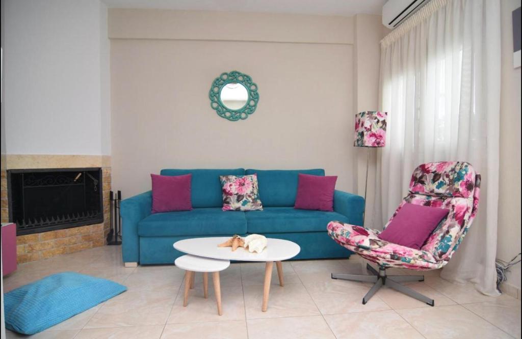 尼基季Our little paradise ! Nikiti !的客厅配有蓝色的沙发和两把椅子